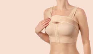 Woman wearing compression bra while she heals from mommy makeover surgery
